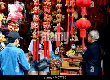 Young Chinese couple buying lunar new year decorations at a store in Chinatown, Singapore Stock Photo