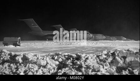 C-17A Globemaster IIIs and C-5M Super Galaxies sit on the snow-covered flight line Jan. 5, 2018, at Dover Air Force Base, Del. Eight inches of snow fell at Dover Stock Photo