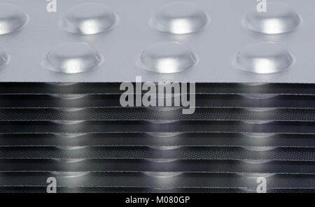 Pharmaceutical Drugs blister packs stacked up high and filled with tablets. Partial view with shallow focus, with side view close up from above in cro Stock Photo