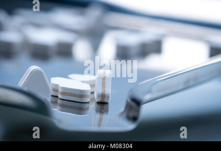 Macro shot of triangle shape tablet pills. Three layers tablet pills for indication antacid, digestive and gastric pain. Group of sandwich tablets pil Stock Photo