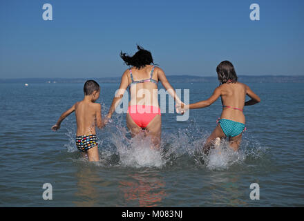 Mother with her children playing in water