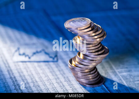 Wobbly stack with euro coins with foreign exchange rates Stock Photo