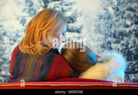 Mother hugging and comforting her daughter in winter time Stock Photo