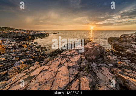Sunset over the sea and the rocks at the beach at Hovs Hallar nature reserve on the Bjare Peninsula, Bastad, Skane, Sweden, Scandinavia. Stock Photo