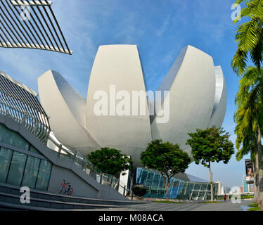 Singapore, Singapore - December 11, 2017. Exterior view of flower-shaped ArtScience Museum in Singapore, with surrounding modern buildings, people and Stock Photo