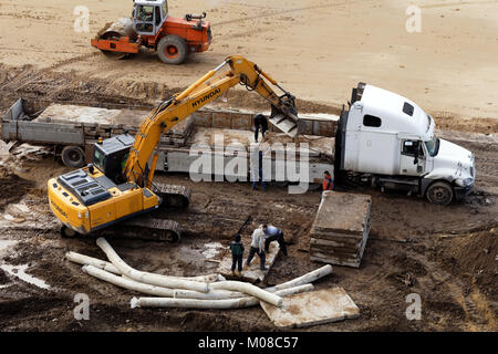 St. Petersburg, Russia - September 12, 2017: Excavator unloading concrete slabs on a construction site. The Construction Equipment Division of Korean  Stock Photo