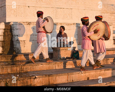 Traditional Rajasthani drummers serenade a traveller on the ghats, Pushkar, Rajasthan, India Stock Photo
