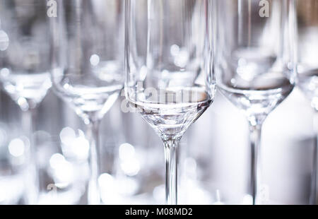 Elegant luxury shiny wine glasses lined up in rows on bar table background image Stock Photo