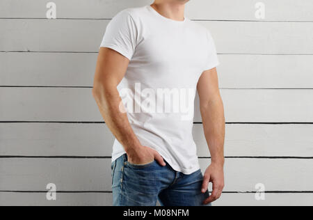 Mockup  T-shirts on a young athletic guy on a white wooden background. Front view Stock Photo