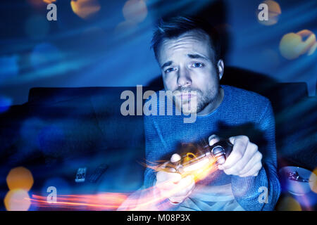 Man playing video games at night Stock Photo