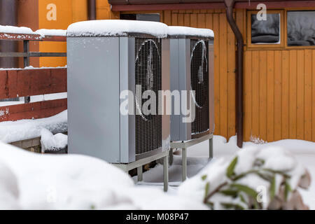 Two residential modern heat pumps buried in snow Stock Photo