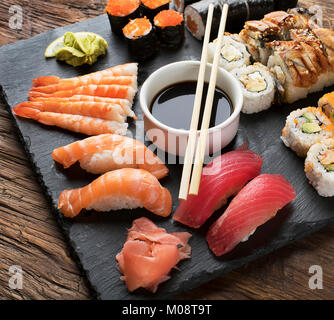 Sushi Set nigiri, sushi rolls and sashimi served on stone slate. Stock Photo