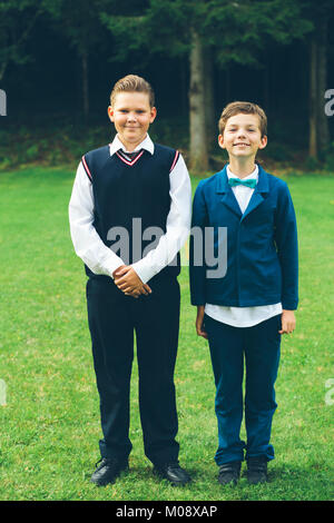 Formal portrait of two schoolboys standing next to forest. Stock Photo