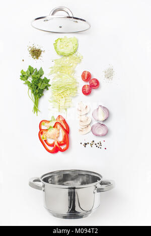 Assorted fresh vegetables falling into a bowl, on white background Stock Photo