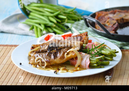 Fried lamb chops with onions and bacon-wrapped green beans Stock Photo