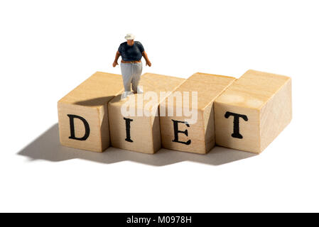 Bad Diet leading to obesity and weight problems in a conceptual image of a miniature Fat Boy figure standing on wooden blocks with the word - Diet ove Stock Photo