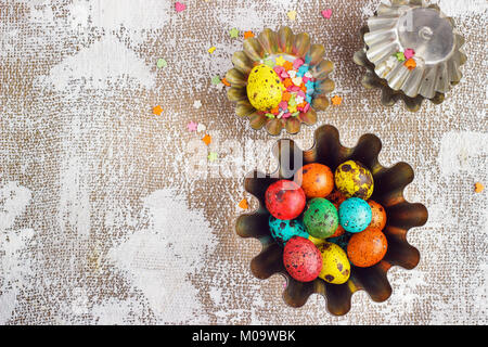 Colored easter eggs and baking molds on a light canvas background,place for text. Stock Photo