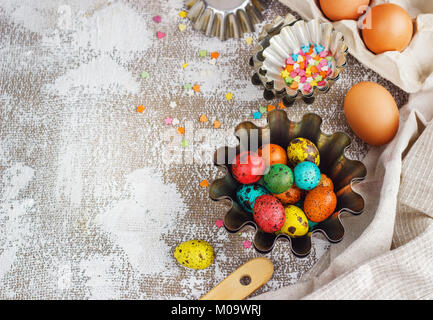 Colored easter eggs and baking molds on a light canvas background,place for text. Stock Photo