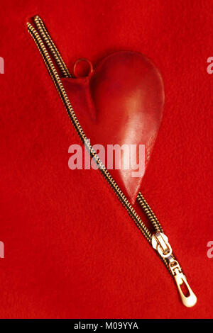 Red heart in red zipper pocket on a red background, wedding or festive concept Stock Photo