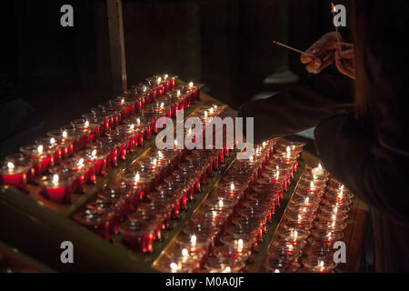 People lighting candles in the Notre Dame cathedral in Paris, France. Burning a candle is a usual practice in Catholicism for praying.  Picture of peo Stock Photo