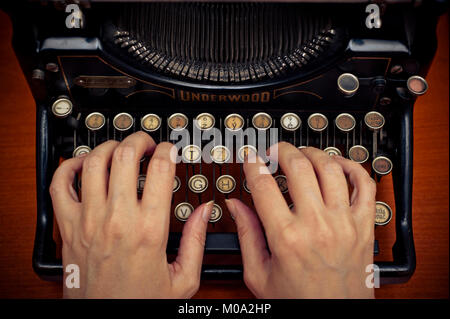 woman typing on a mechanical antique Underwood typewriter Stock Photo