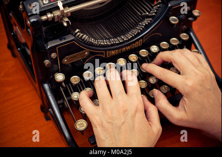 woman typing on a mechanical antique Underwood typewriter Stock Photo