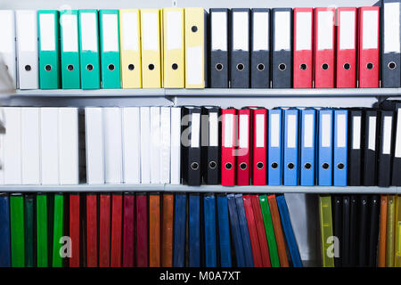 Many folders standing on shelfs in the store Stock Photo