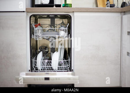Dishwasher machine in modern kitchen load with plates and glasses Stock Photo