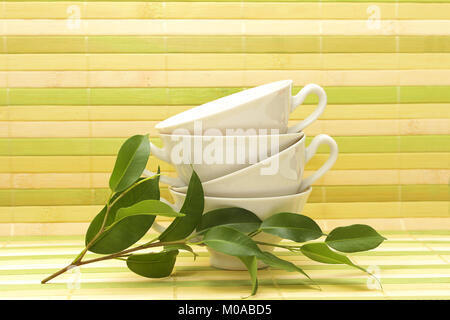 Four white porcelain cups on a striped mat Stock Photo