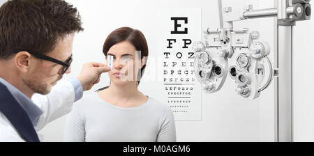 optometrist examining eyesight, woman patient pointing at the chart, eyes exam test Stock Photo