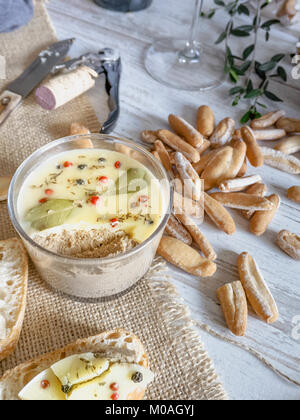 Fresh homemade chicken liver pate decorated with melted butter, bay leaves and black and red pepper on rustic background Stock Photo
