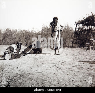 A late 19th or early 20th century black and white photograph of three Bedouin men in Jordan, in the Middle East. Stock Photo