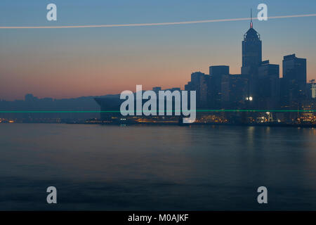 Light Trails OF A Passing Ferry And The Skyline Of Wan Chai And Victoria Harbour At Sunrise. Hong Kong. Stock Photo