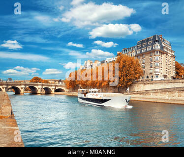 Passenger boat passes Pont Neuf on Seine river in Autumn Stock Photo