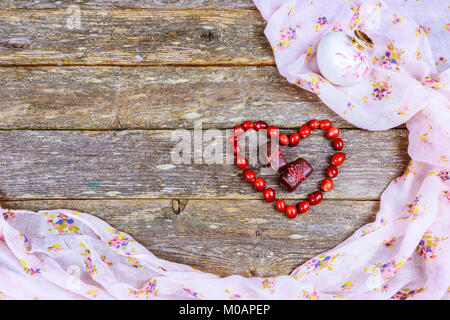 Heart laid out from buttons in the form of multi-colored paws on a wooden laid out heart on an old wooden background Stock Photo