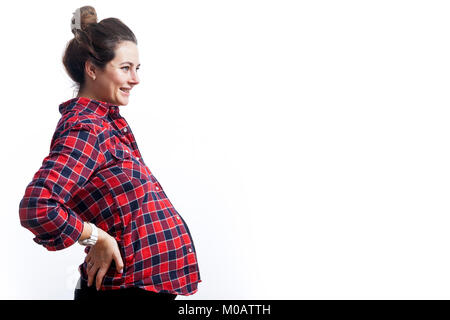 Young dark-haired woman at 37 weeks gestation in black dress and plaid shirt smiles and holds on to the back on isolated white background, side view Stock Photo