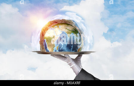 Hand of waitress presenting Earth globe on tray. Stock Photo