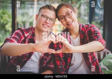 young couple in love hold hand together to form heart shape. boyfriend & girlfriend dating in valentine's day. relationship, lover lifestyle concept Stock Photo