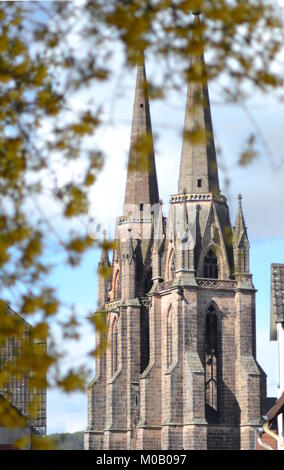 A view of the church of Marburg with tree in foreground and blue sky in background Stock Photo