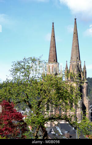 A view of the church of Marburg with tree in foreground and blue sky in background Stock Photo