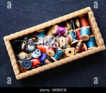 Wooden retro box, with thread spools and buttons. Sewing accessories. Stock Photo
