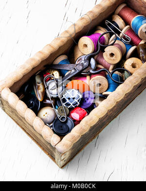 Wooden retro box, with thread spools and buttons. Sewing accessories. Stock Photo