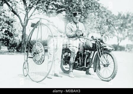 Motorcycle Cop chased down a rider on a velocipede or Penny Farthing Bicycle and gives him a ticket Stock Photo
