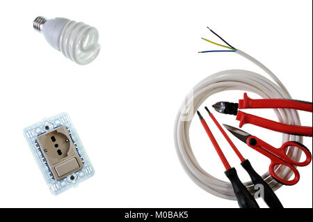 Scissors, screwdrivers, switch, socket, light bulb, cable cutter and power cable for a residential electrical installation, photographed on a white ba Stock Photo