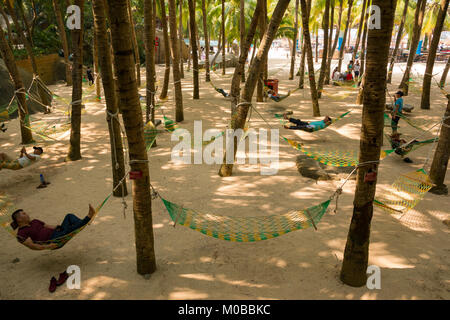 HAINAN, CHINA - 26.10.2017: people resting in hammocks on palm tree in park in Hainan, China Stock Photo