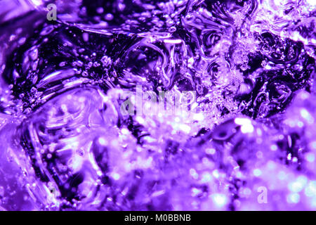 Frozen water bubbles in purple ice. A small iceberg in the water Stock Photo