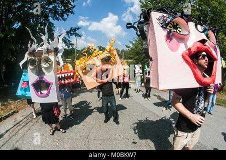 Atlanta, GA, USA - September 23, 2017:  People wearing huge handmade custom masks walk in the East Atlanta Strut festival parade in Atlanta. Stock Photo