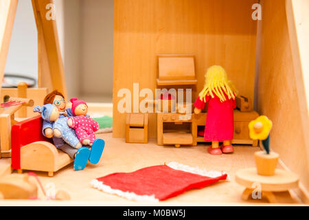 Closeup of wooden dollhouse family enjoying their time together Stock Photo