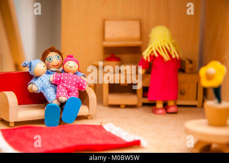 Closeup of wooden dollhouse family enjoying their time together Stock Photo