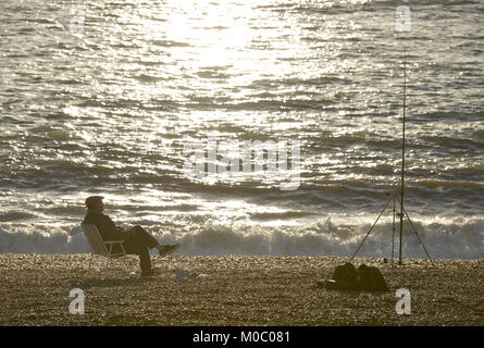 Old man relaxing on a chair whilst sea fishing in Seaford, East Sussex. Stock Photo